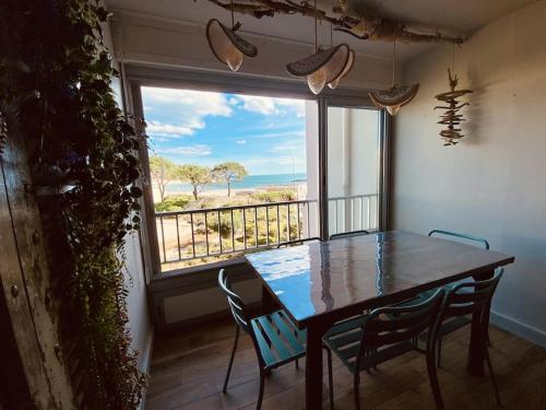 une salle à manger avec une table et une vue sur l'océan dans l'établissement Sète-Vue mer-#monabridelaplage, à Sète