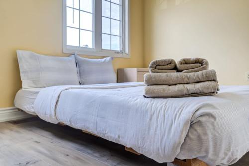 a bedroom with a bed with towels on it at Brampton Retreat - Quiet 2BR Residential Area in Brampton