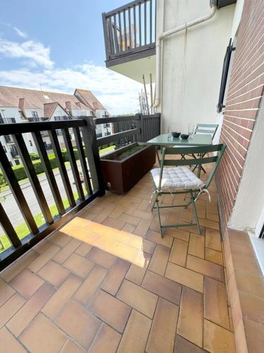 d'une terrasse avec une table et une chaise sur un balcon. dans l'établissement Cabourg Plage 5, à Cabourg