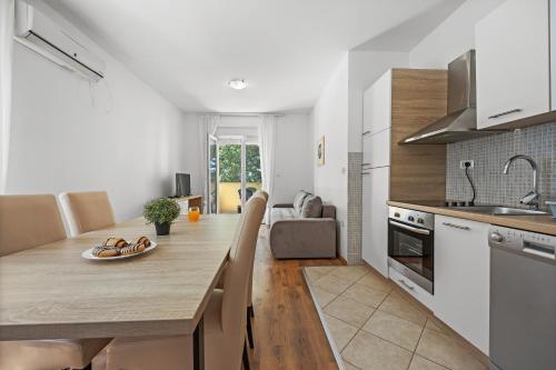 - une cuisine avec une grande table en bois dans l'établissement NEEA Apartments, à Medulin