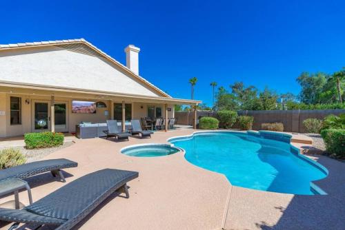 a swimming pool with benches and a house at Luxury Scottsdale Retreat Heated Pool and Mini Golf in Phoenix