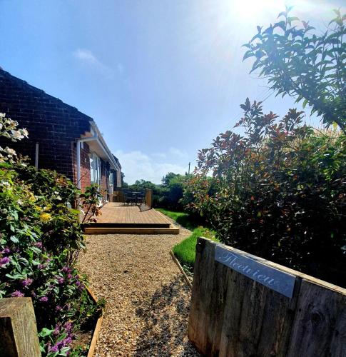 a house with a wooden fence and some bushes at Seaview Self Catering-Fleetview in Weymouth