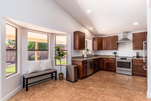 a kitchen with wooden cabinets and a bench in it at Luxury Scottsdale Retreat Heated Pool and Mini Golf in Phoenix