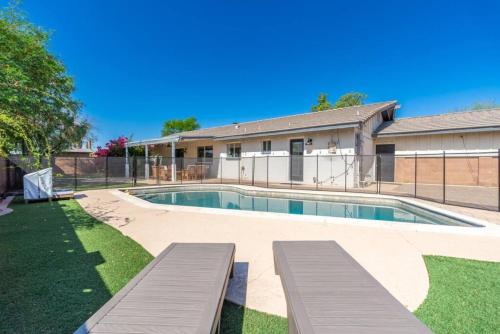 a swimming pool with benches in front of a building at Sunshine, Paradise Escape! Private Pool, Sleeps 12 in Phoenix