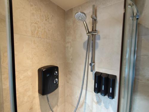 a shower with a shower head in a bathroom at Richmond Lane Guest House - AA Accredited in Romsey