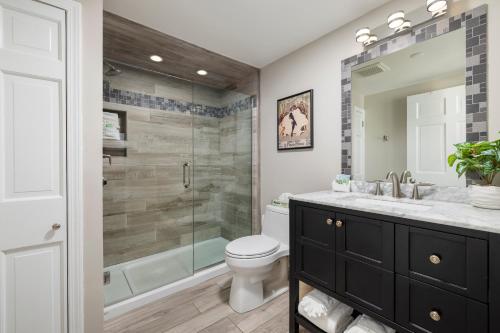 a bathroom with a shower and a toilet and a sink at Old Harbor Inn in South Haven