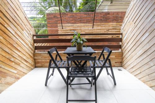 a table with two chairs and a potted plant on a patio at Flat Pipa Oceano in Pipa