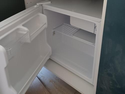 un réfrigérateur blanc vide avec sa porte ouverte dans l'établissement Studio M proche des thermes de Royat Chamalières à pieds, à Chamalières