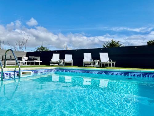 a swimming pool with chairs sitting next to a fence at Atlantis Holiday Apartments in Torquay