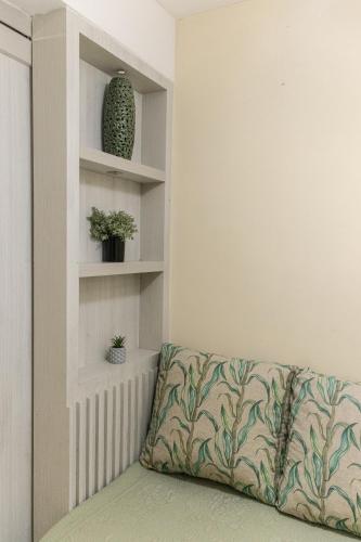 a couch in a living room with plants on shelves at Flat Pipa Oceano in Pipa