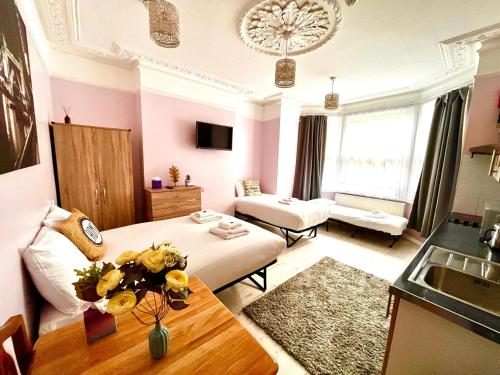 a living room with a bed and a table in a room at United Lodge Hotel in London