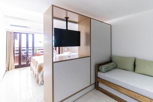 a hotel room with a bed and a tv at Flat Pipa Oceano in Pipa