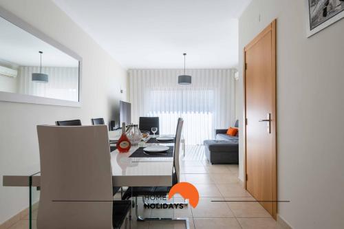 a dining room and living room with a dining table at #226 Vila LII by Home Holidays in Albufeira