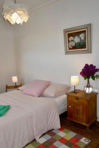 - une chambre avec 2 lits et un vase de fleurs sur une table dans l'établissement Poppy Cottage lovely fully-equipped cottage for 6 people, à Barneville-Carteret