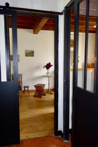 une porte ouverte menant à une chambre avec une table dans l'établissement Poppy Cottage lovely fully-equipped cottage for 6 people, à Barneville-Carteret