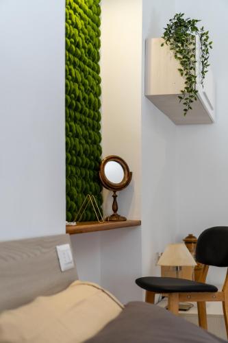 a room with a green wall with two chairs and a bed at L'ombelico del Monte - appartamenti in centro storico in Piazza Armerina