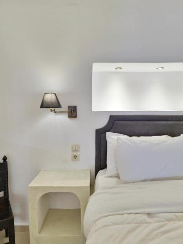 a bedroom with a bed with a table next to it at Karpimo Horizon - Caldera View with private hot tub in Firostefani