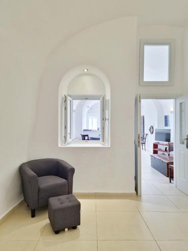 a chair and a ottoman in a living room at Karpimo Horizon - Caldera View with private hot tub in Firostefani
