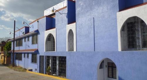a blue and white building with arched windows at Hotel Huautla de Oaxaca in Oaxaca City