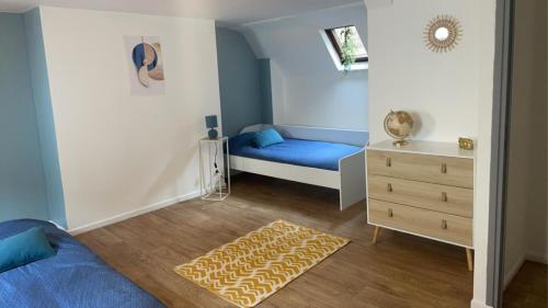 - une chambre avec un lit bleu et une commode dans l'établissement COSY TRIPLEX PLEIN CENTRE maison de ville, à Boulogne-sur-Mer