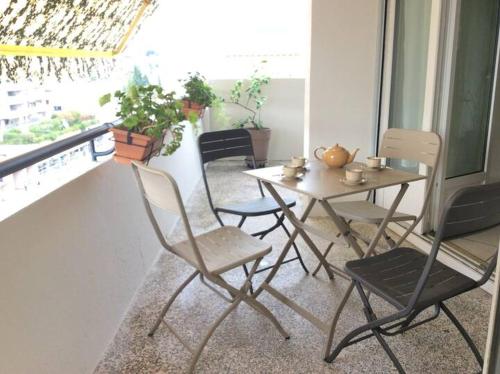 Cette chambre dispose d'un balcon avec une table et des chaises. dans l'établissement Spacieux 2 pièces, au Cannet