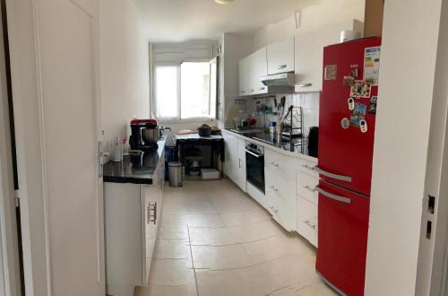 cocina con armarios blancos y nevera roja en 【Vitry-sur-Seine】 Appartements confortables de 2 chambres et 1 salon à louer en Vitry-sur-Seine