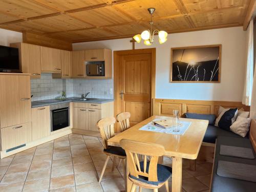 a kitchen and dining room with a table and chairs at Rasterhof in Sillian