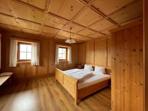 1 dormitorio con 1 cama en una habitación de madera en Rasterhof en Sillian
