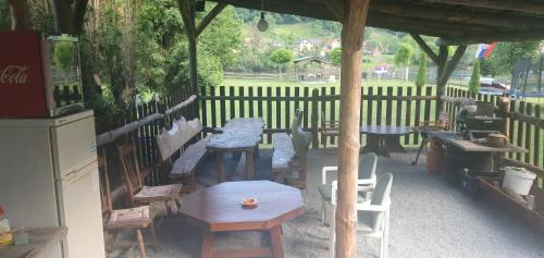 a group of tables and chairs under a pavilion at Kamp kućica trokrevetna in Crnča
