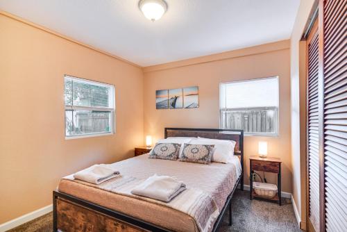 a bedroom with a bed and two windows at Cozy St Pete Home about 2 Mi to Madeira Beach! in Redington Shores
