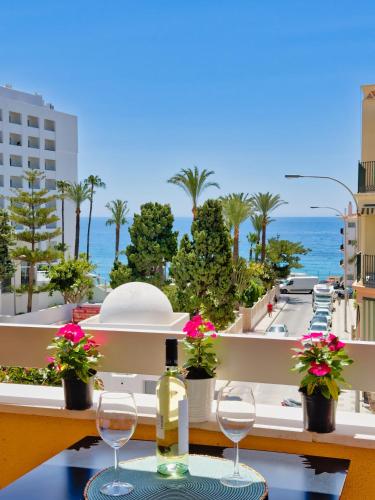 a table with wine glasses and a view of the ocean at Apt Del Mediterraneo View in Nerja