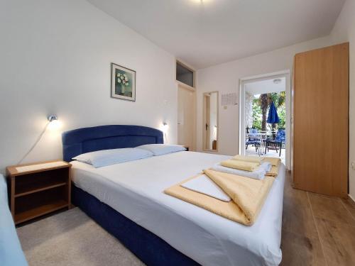 een slaapkamer met een groot bed met een blauw hoofdeinde bij Apartments Danica in Dramalj