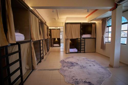 a room with several bunk beds and a rug in a room at Some Place Else in George Town