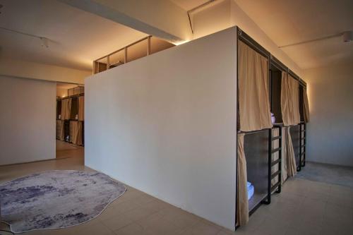a room with a large white wall with a bed at Some Place Else in George Town