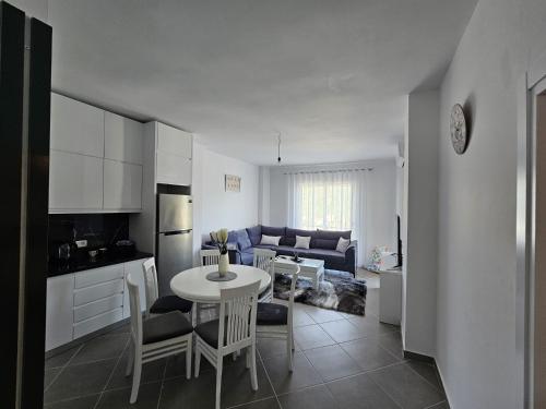 Una cocina y una sala de estar con mesa y sillas. en Luxury Apartment Hannah, en Vlorë