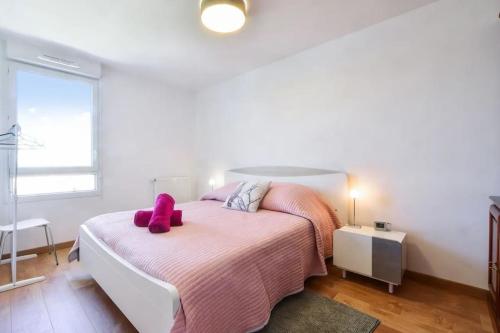 ein Schlafzimmer mit einem Bett, auf dem ein rosa Stofftier liegt in der Unterkunft Beautiful apartment with terrace Annecy in Annecy