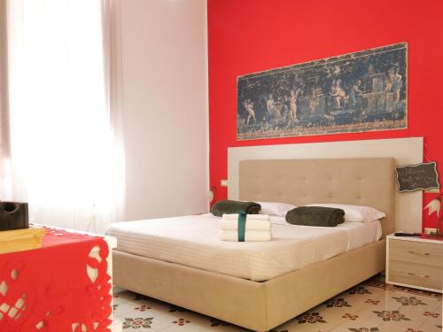 - une chambre dotée d'un lit avec un mur rouge dans l'établissement V&V Suite & Breakfast, à Pompéi