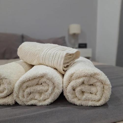 a pile of towels sitting on top of a bed at Hotel Los Angeles in Santa Teresita