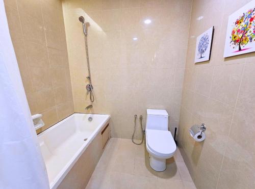 a bathroom with a toilet and a tub and a sink at Sunway Studio Homestay with Balcony Theme Park View Connecting Sunway Pyramid Mall & Sunway Lagoon in Petaling Jaya