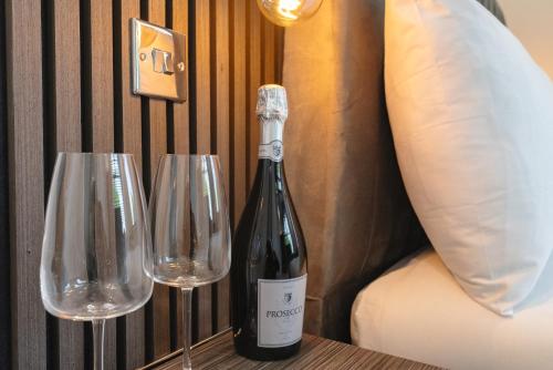 una botella de vino y dos copas de vino en una mesa en OYO Bellevue Apartments Middlesborough en Middlesbrough