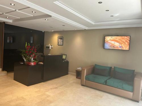 a living room with a couch and a tv on the wall at Yto boutique Hotel in Casablanca