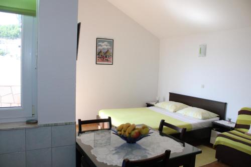 a room with a bed and a table with a bowl of fruit at Studio apartment in Duce with sea view, balcony, air conditioning, WiFi 5067-6 in Duće