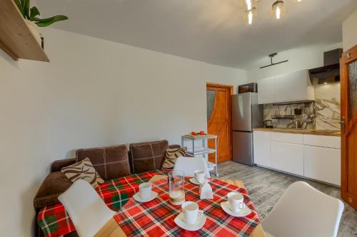 a living room with a table and chairs and a kitchen at Apartamenty Szwarcowa in Tylicz