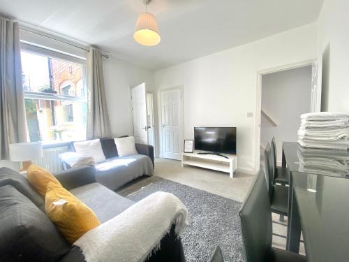 a living room with a couch and a tv at Rushden - Spacious House and Garden, Free Parking, TV, Sleeps 8 Guests in Rushden