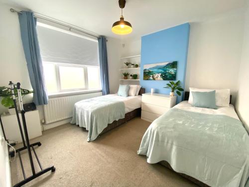 ラッシュデンにあるRushden - Spacious House and Garden, Free Parking, TV, Sleeps 8 Guestsのベッド2台と窓のある寝室