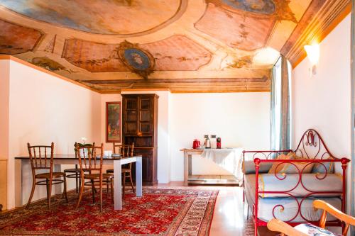 a living room with a table and a ceiling at Cascina Ambrosia Residenza d'Epoca in Asti