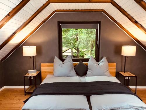 a bedroom with a large bed with two lamps at Gästehaus am Aller Radweg in Wietze