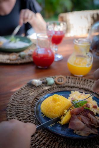 una mesa con un plato azul de comida y bebida en Vila Bem Te VI Trancoso, en Trancoso