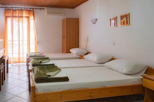 a room with two beds and a window at HOTEL PAVLOS in Paralia Katerinis