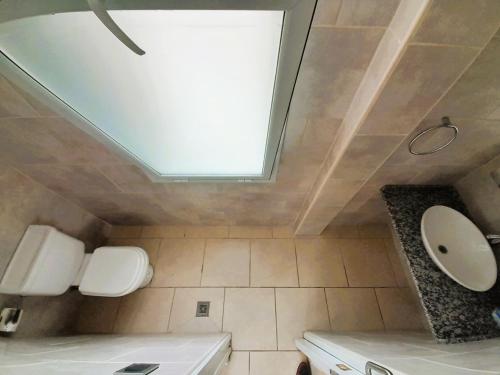 a bathroom with a toilet and a skylight at Los Ancares Resort in Mina Clavero